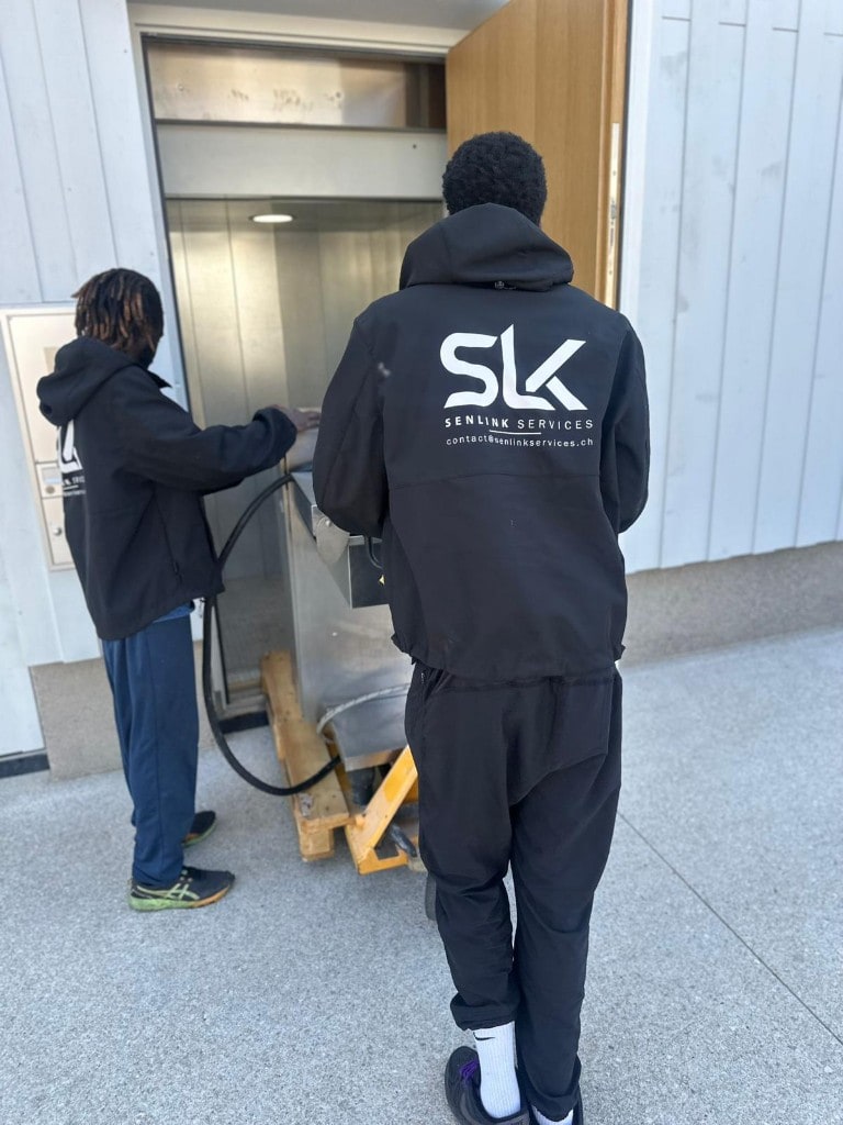 Équipe Senlink en intervention — manutention avec transpalette près d’un accès