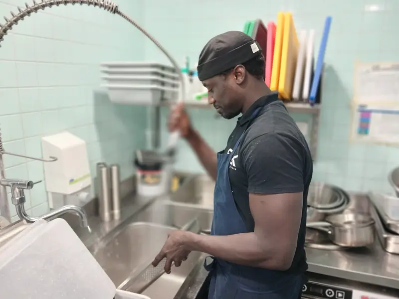 Plongeur SENLINK rinçant la vaisselle au poste de lavage
