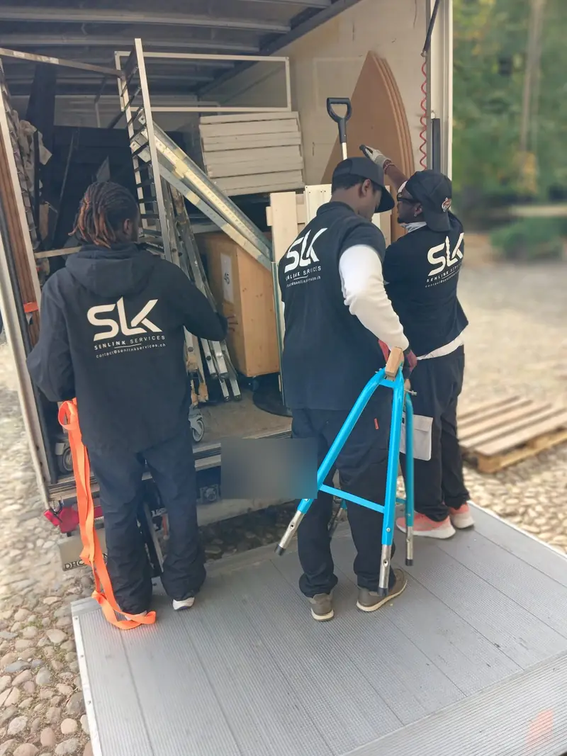 Mitglieder des SENLINK-Teams beim Entladen eines Lastwagens mit einer Sackkarre